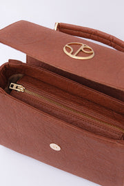 A chic London LHR - Piñatex® Saddle Bag - Mocha with a gold clasp, partially open to reveal an inner zipper pocket, crafted from Piñatex®, by 1 People.