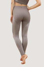 Person wearing 1 People's high-waisted, grey athletic leggings made from recycled polyamide, shown from the back to feature the full length of the ankle-length Stockholm ARN - Leggings - Jasper and part of a matching sports top.